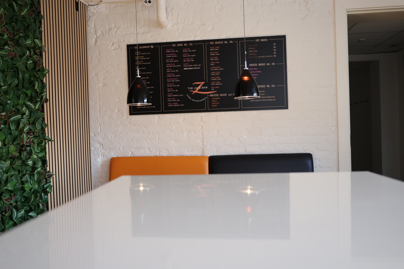 Siddeplads hos The Juize Bar med menutavle på væggen